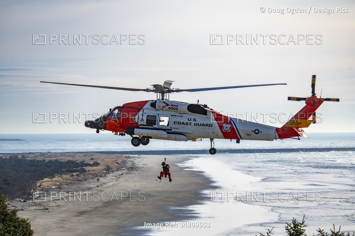 U. S. Coast Guard crew suspended below a Sikorsky MH-60J Jayhawk Performing ...